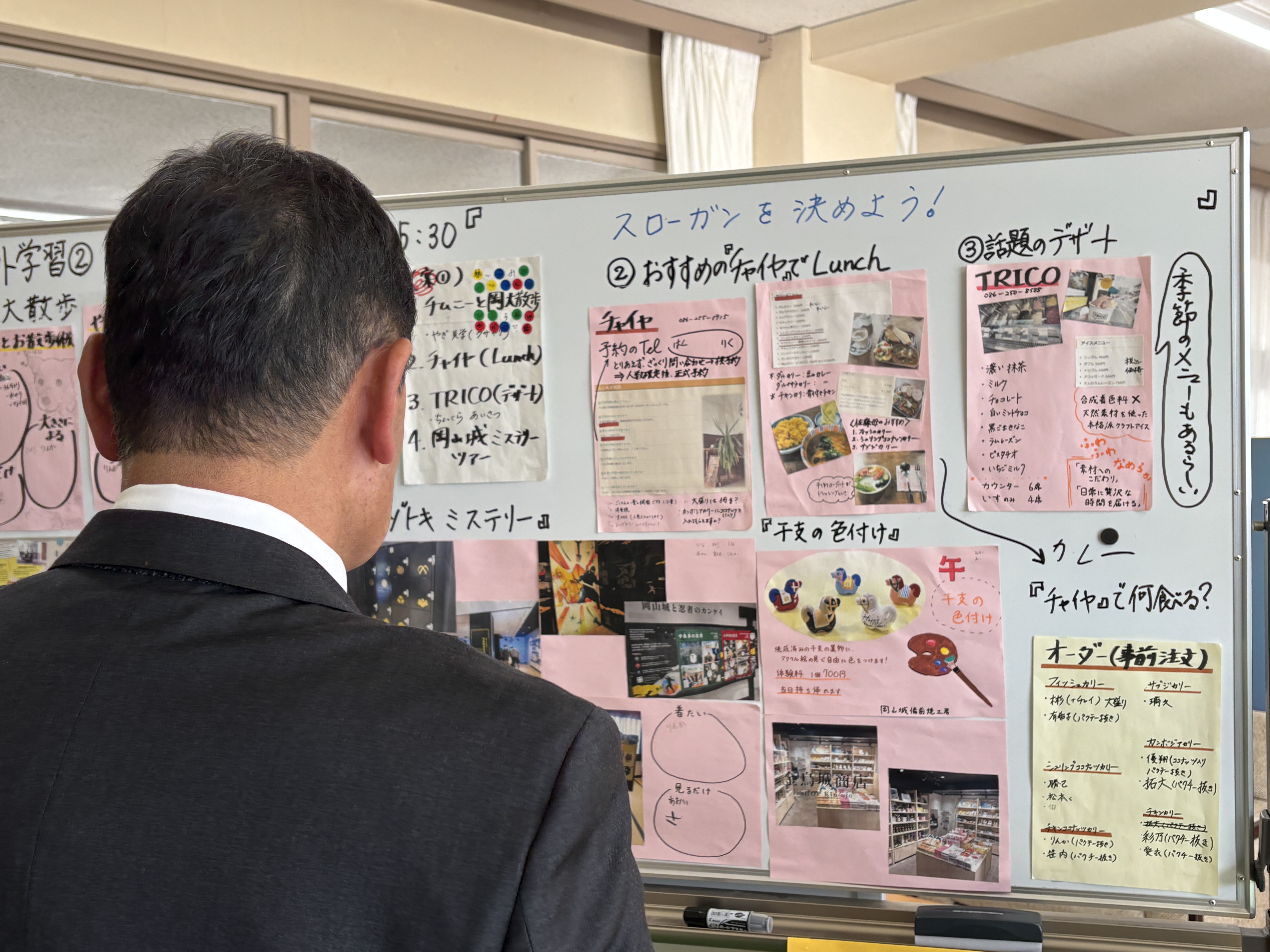 校外学習活動についてまとめたホワイトボードを見る細川委員